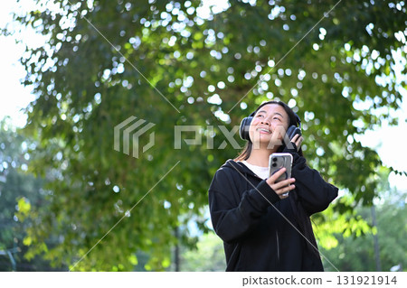 Cheerful high school student listening to songs on smartphone during break time 131921914