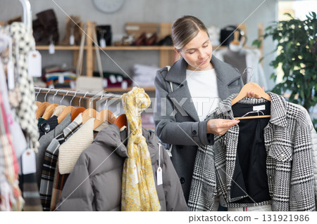 European woman near showcase pick out and buying plaid jacket coat European woman near showcase pick out and buying plaid jacket coat 131921986