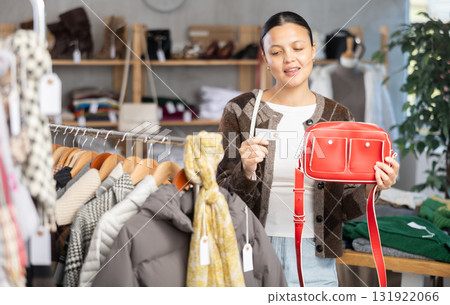 Adult woman choosing handbag in clothing store 131922066