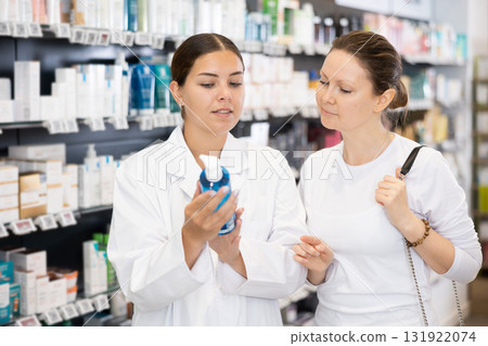 Woman pharmacist helping woman customer to choose cosmetic product Woman pharmacist helping woman customer to choose cosmetic product 131922074