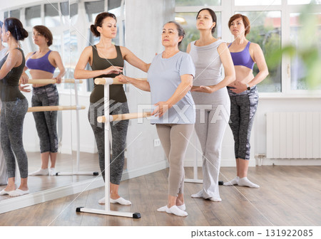 Adult woman teacher correcting beginning dancers 131922085