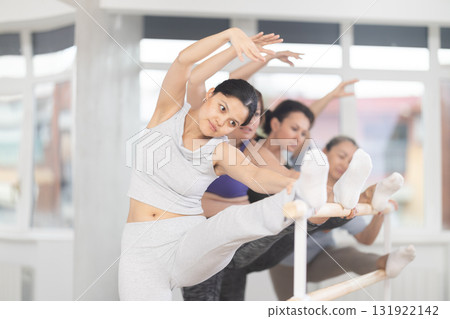 Ballet pose grand batman - women of different ages at choreography lesson Ballet pose grand batman - women of different ages at choreography lesson 131922142