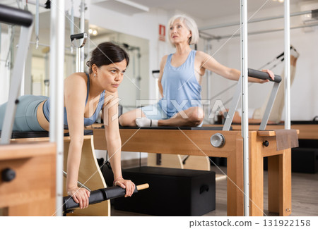 Young asian girl practicing pilates exercises on combo chair 131922158