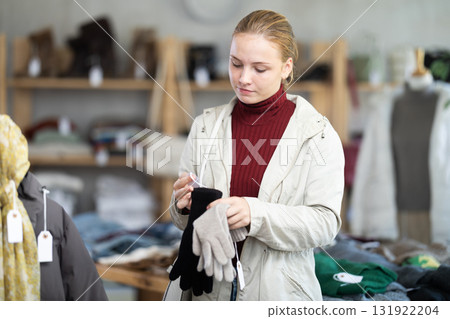 Teenage girl choosing winter gloves in clothing store Teenage girl choosing winter gloves in clothing store 131922204