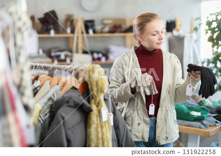 Teenage girl choosing winter gloves in clothing store Teenage girl choosing winter gloves in clothing store 131922258