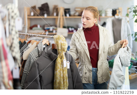 While shopping, teen girl browsing goods items and choose elect something warm outerwear in store While shopping, teen girl browsing goods items and choose elect something warm outerwear in store 131922259