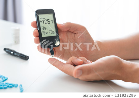 Patient checking blood sugar level with glucometer 131922299