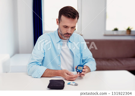 Patient checking blood sugar level with glucometer 131922304
