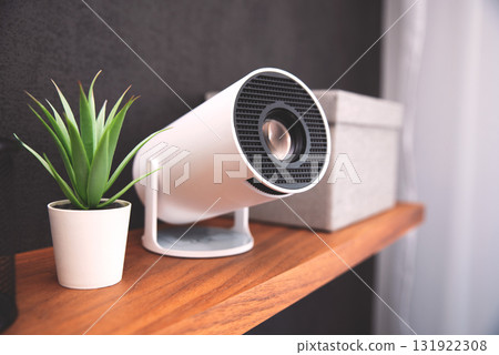 White projector with a lens on shelf 131922308
