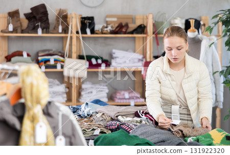 Selective teen girl choosing sweater in clothing store Selective teen girl choosing sweater in clothing store 131922320