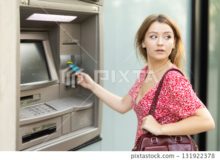 Young woman using card at atm 131922378