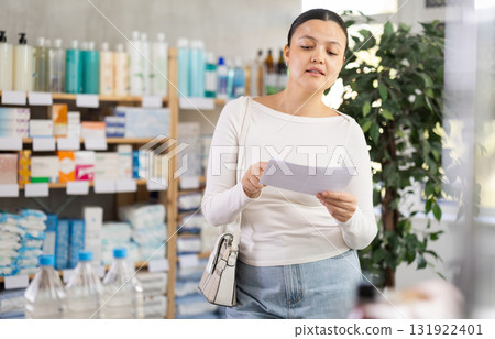 Middle-aged woman looking for something in drugstore 131922401