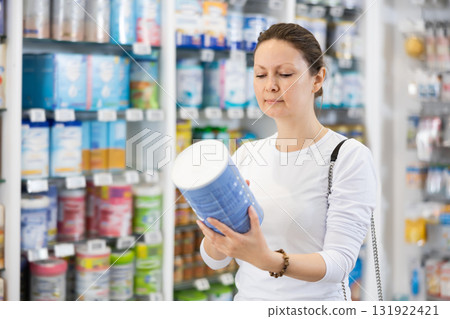 Adult woman chooses baby formula in pharmacy Adult woman chooses baby formula in pharmacy 131922421