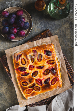 Sweet homemade focaccia with berries on paper on the table top and vertical view Sweet homemade focaccia with berries on paper on the table top and vertical view 131922437