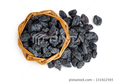 black raisins in wicker basket isolated on white background. Top view. Flat lay black raisins in wicker basket isolated on white background. Top view. Flat lay 131922565