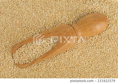 white quinoa seeds in wooden scoop as a background. Top view. Flat lay 131922579