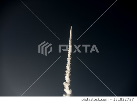 Rocket launching into the sky, leaving a trail of smoke against a dark background Rocket launching into the sky, leaving a trail of smoke against a dark background 131922787