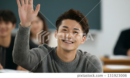 一名 20 多歲的男學生在教室裡舉手 一名 20 多歲的男學生在教室裡舉手 131923006