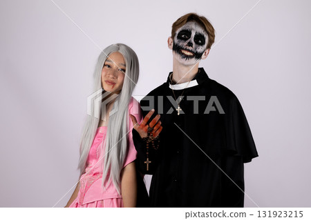 Man and woman dressed as skeletons embrace in halloween costumes at spooky party 131923215