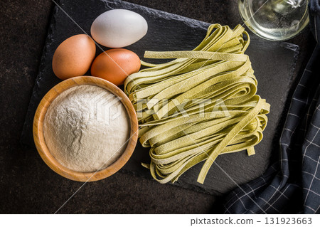 Green tagliatelle pasta on black table. Top view. Green tagliatelle pasta on black table. Top view. 131923663