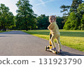 Girl on scooter. Riding child outdoor fun. Sunshine road freedom lifestyle. 131923790
