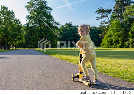 Girl on scooter. Riding child outdoor fun. Sunshine road freedom lifestyle. Girl on scooter. Riding child outdoor fun. Sunshine road freedom lifestyle. 131923790