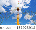 [Material] Low angle view of a ship's mast with signal flags and climbing net against a blue sky. 131923918