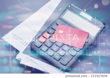 Red credit card, calculator and documents on a table in office with stock market data overlay. Technology concept personal finance, budgeting, online payments and accounting. 131923936