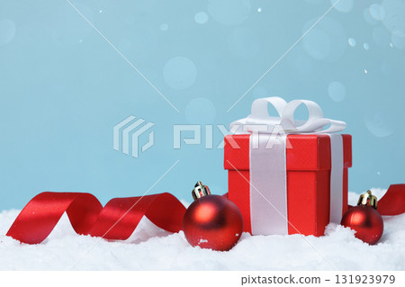 A Festive Red Gift Box Adorned with Colorful Ornaments in a Beautiful Winter Setting A Festive Red Gift Box Adorned with Colorful Ornaments in a Beautiful Winter Setting 131923979