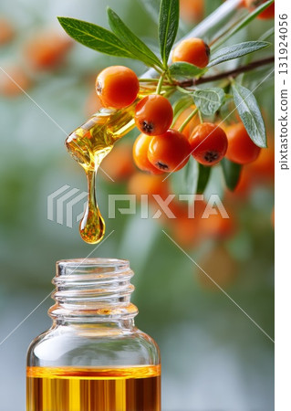Sea buckthorn oil dropper releasing golden droplet above glass bottle with vibrant berries 131924056