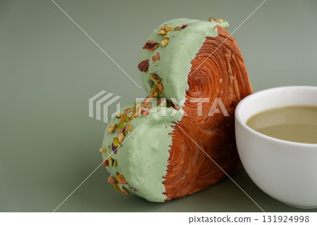 Drink beverage coffee cappuccino latte Delicious fresh croissant topped with Matcha Green Tea flavor Ganache. Creation unique heart shape bakery. Puff pastry holiday love gift present idea Valentine's 131924998