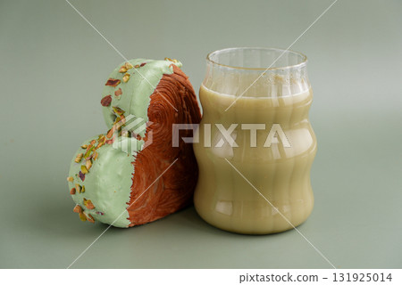 Green tea Matcha latte cappuccino beverage Morning breakfast gift idea Heart shaped pistachio croissant on green background with copy space. Puff pastry trendy sweet dessert bakery. Creamy dough 131925014