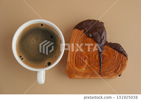 Coffee latte cappuccino drink beverage morning breakfast Heart shaped dark chocolate croissant on beige background with copy space. Puff pastry new trendy sweet dessert bakery. Creamy dough Coffee latte cappuccino drink beverage morning breakfast Heart shaped dark chocolate croissant on beige background with copy space. Puff pastry new trendy sweet dessert bakery. Creamy dough 131925038