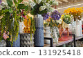 Colorful assortment of fresh flowers in decorative vases displayed on a shelf, showcasing vibrant blooms and unique textures in a bright, inviting floral shop environment 131925418