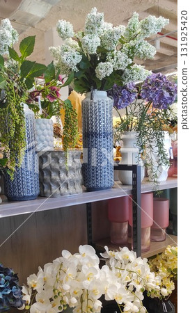 Colorful floral arrangement displayed in decorative vases on a shelf, showcasing various textures and vibrant colors, creating a lively atmosphere in a modern interior space 131925420