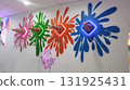 Colorful wall display featuring ice cream cones with vibrant splashes of paint, illuminated by neon lights, creating a playful and inviting atmosphere for sweet treats 131925431