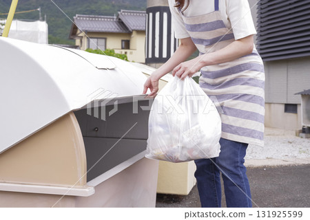 一名繫著圍裙的婦女正在清理家庭垃圾 131925599