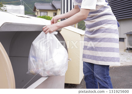 一名繫著圍裙的婦女正在清理家庭垃圾 131925600