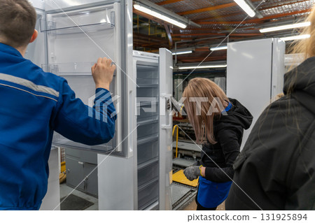 A male and a female worker are shown on a production line in a factory A male and a female worker are shown on a production line in a factory 131925894