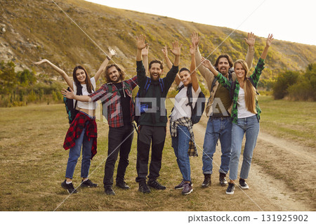 Overjoyed group of tourists looking at camera during walking tour in nature with backpacks. Overjoyed group of tourists looking at camera during walking tour in nature with backpacks. 131925902