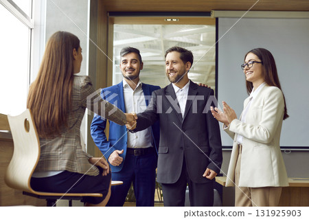 Business People Exchange Smiles and Handshake in the Office 131925903