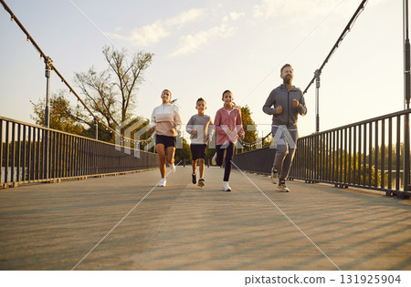Happy Family With Two Children Jogging In The City Park At Sunset 131925904