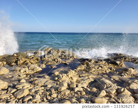 Tranquil Coastal Waves Gently Crash onto the Beautiful Rocky Beach as the Sun Sets in the Horizon 131926257