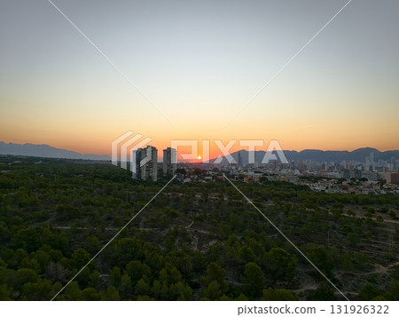 A stunning sunset gracefully illuminates the urban skyline and surrounding nature A stunning sunset gracefully illuminates the urban skyline and surrounding nature 131926322