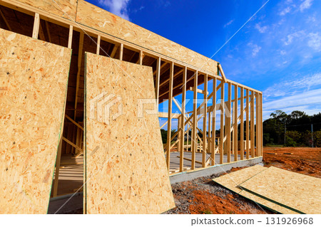 Workers are building is beams framework wooden house with large plywood panels in under works day 131926968