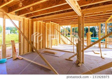 Framed wooden beams walls at construction site during works day active building work. Framed wooden beams walls at construction site during works day active building work. 131926973