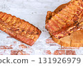 Grilled smoked flavorful ribs sit on wooden board, juicy, flavorful dish perfect for an outdoor barbecue. 131926979