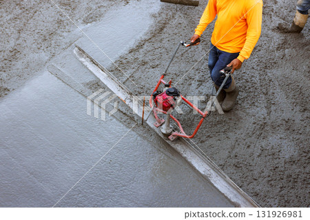 Construction workers are smoothing freshly poured concrete with power trowel Construction workers are smoothing freshly poured concrete with power trowel 131926981