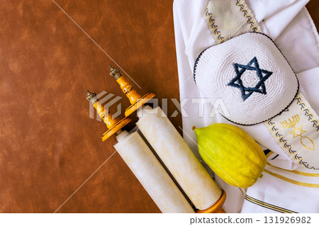 Traditional Jewish tallit prayer shawl on table during religious Sukkot festival, etrog Traditional Jewish tallit prayer shawl on table during religious Sukkot festival, etrog 131926982