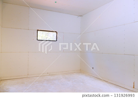Bare walls small window define this unfinished room, illuminated by light coming in from outside. Bare walls small window define this unfinished room, illuminated by light coming in from outside. 131926993